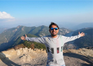 a man standing on a mountain with his arms out